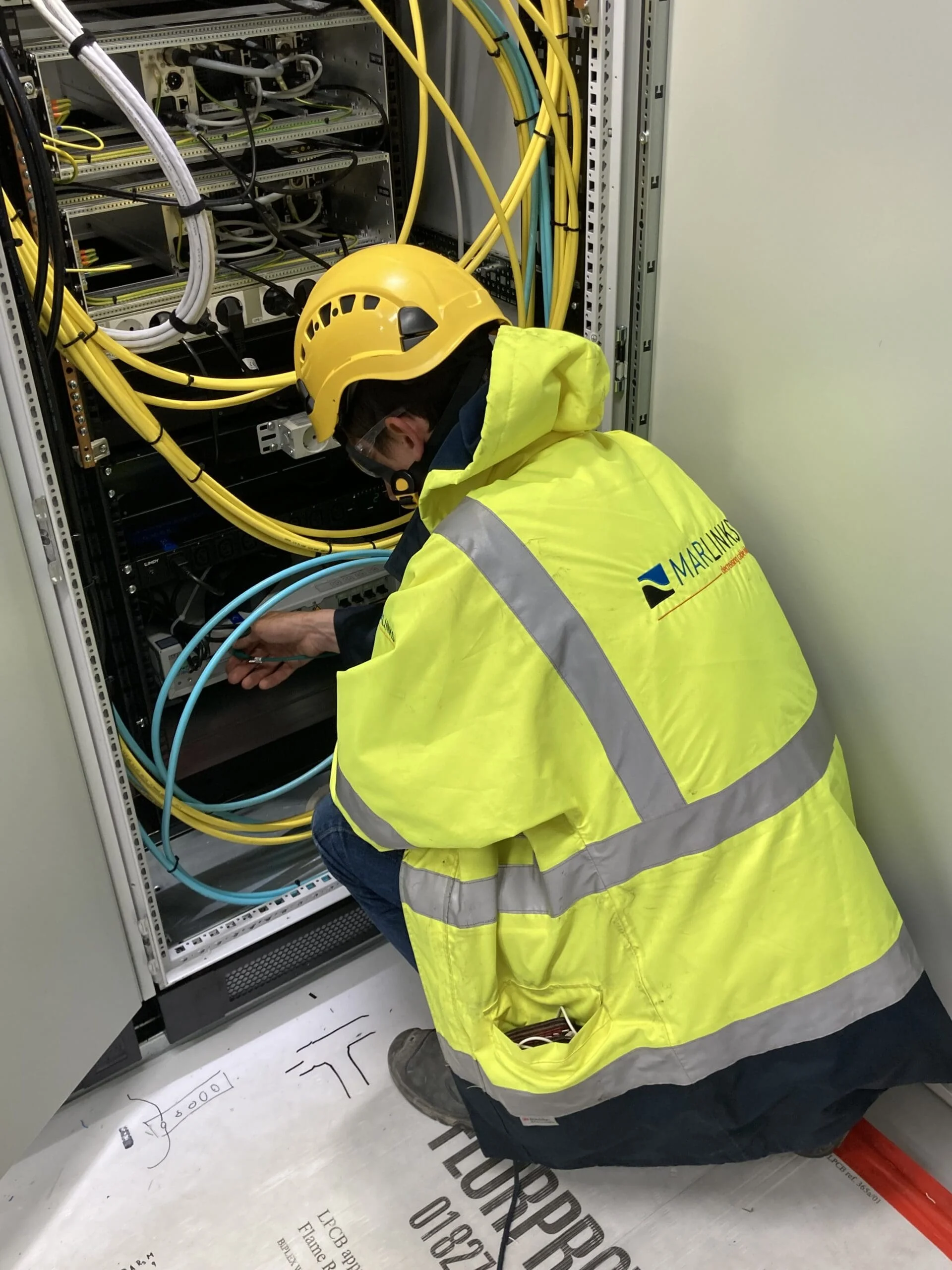 engineer working on cabinet at offshore substation installing dts for subsea cable monitoring