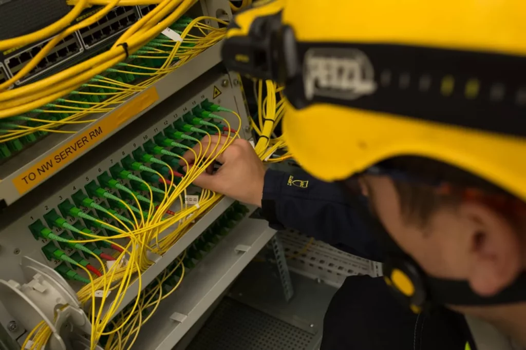engineer installing optical fibers at substation