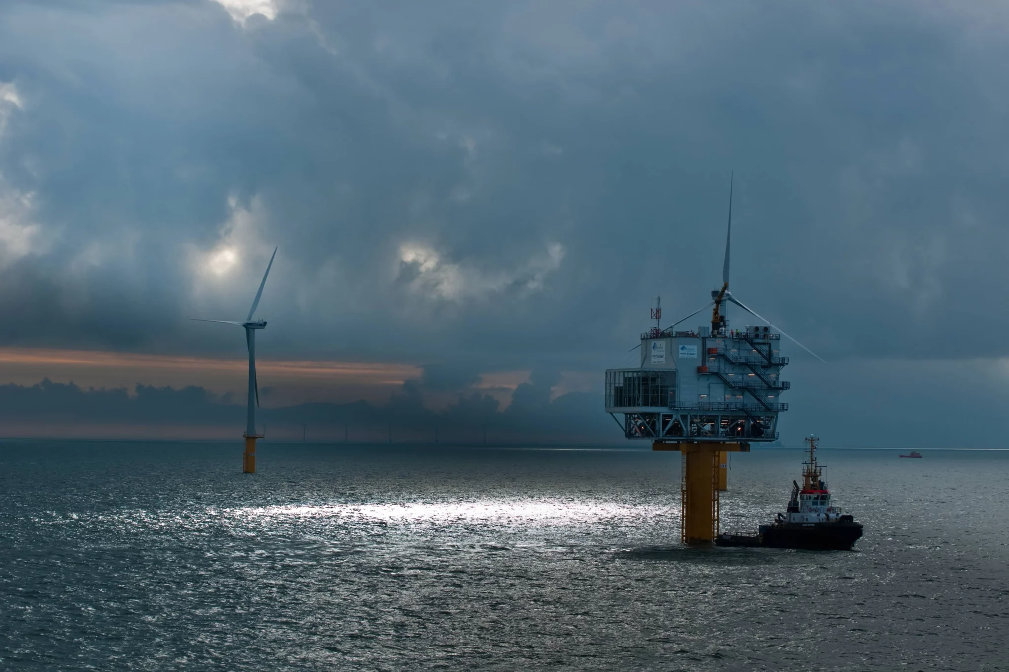 offshore wind farm with substation and vessel in the dark